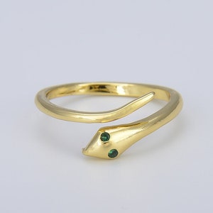 May include: A gold snake ring with two green gemstones for eyes.