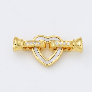 May include: Gold-tone heart-shaped clasp with clear crystal accents. The clasp is designed to be used for necklaces or bracelets.