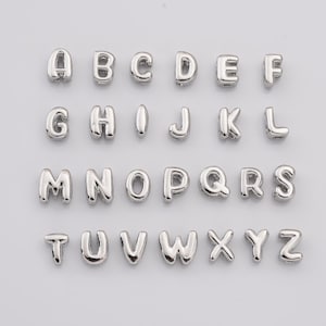 Op de afbeelding: Zilveren alfabet letter kralen, van A tot Z, voor het maken van sieraden.