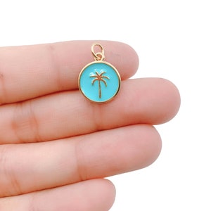 May include: Gold charm with a blue enamel palm tree design.