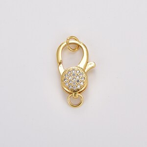 May include: Gold-toned lobster clasp with a round, clear crystal-encrusted accent.