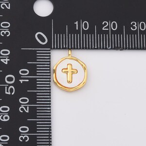 May include: Gold-toned pendant charm with a white enamel cross design. The pendant is approximately 1 cm in diameter.