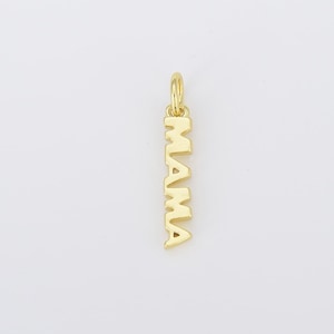 May include: A gold-colored pendant charm with the word "MAMA" vertically displayed. The charm has a small loop at the top for attaching to a necklace or bracelet. The letters are in a bold, sans-serif font.
