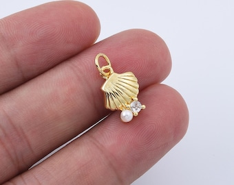 May include: Gold-tone seashell charm with a faux pearl and a clear rhinestone. The charm is perfect for adding a touch of whimsy to jewelry projects.