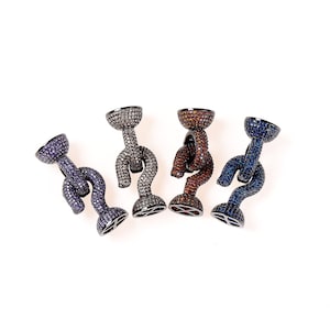 Puede incluir: Cuatro gemelos de metal negro con un diseño único. Cada gemelo está cubierto de pequeñas piedras preciosas de colores. Los gemelos están dispuestos en una fila sobre un fondo blanco.