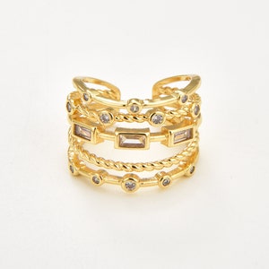 May include: Gold ring with multiple bands and clear cubic zirconia stones. The ring has a twisted rope design and features both round and rectangular stones.
