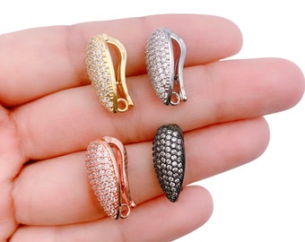 May include: Four different colored metal clasps with clear crystal embellishments. The clasps are in gold, silver, rose gold, and black.