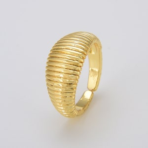 May include: A gold-toned adjustable ring with a ridged, textured band.