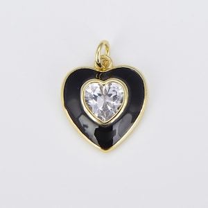 May include: Gold heart-shaped pendant with black enamel and a clear rhinestone in the center.