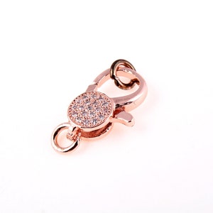 May include: Rose gold tone lobster clasp with a round, clear crystal-encrusted accent.