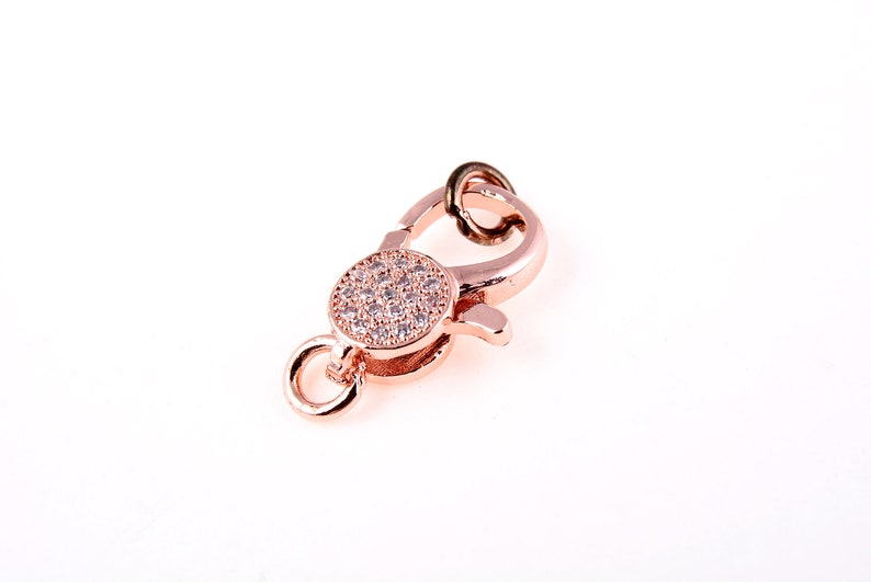 May include: Rose gold tone lobster clasp with a round, clear crystal-encrusted accent.