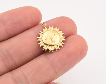 May include: A gold-colored sun charm with a smiling face and spiky rays. The charm has a small loop at the top for attaching to a necklace or bracelet. The charm is approximately 0.75 inches in diameter.