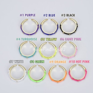 May include: Ten gold rings with different colored enamel, numbered 1 through 10. The colors are purple, blue, black, turquoise, yellow, light pink, white, green, orange, and hot pink.