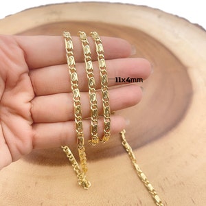 May include: Three gold chains with a 11x4mm link size. The chains are shown on a hand against a wooden background.