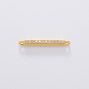 May include: Gold bar charm with clear cubic zirconia stones.