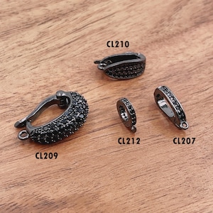 May include: Four black metal clasps with black crystal accents. The clasps are labeled CL210, CL209, CL212, and CL207.