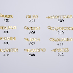 May include: Twelve gold-colored metal charms with the zodiac signs Aries, Taurus, Gemini, Cancer, Leo, Virgo, Libra, Scorpio, Sagittarius, Capricorn, Aquarius, and Pisces. Each charm has a number underneath, from 1 to 12.