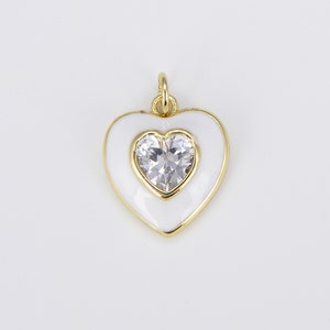 May include: A gold heart-shaped pendant with white enamel and a clear rhinestone in the center.