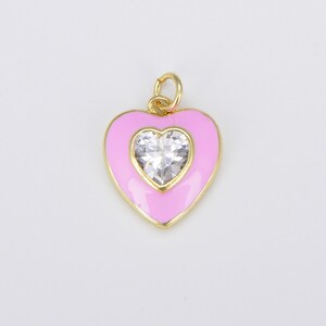 May include: A gold heart-shaped charm with pink enamel and a clear rhinestone in the center.