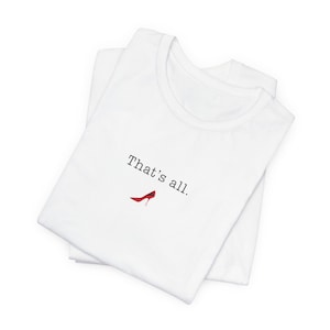 May include: White t-shirt with the text "That's all." and a small red high-heeled shoe graphic. The shirt is folded and appears to be made of a soft, comfortable material.