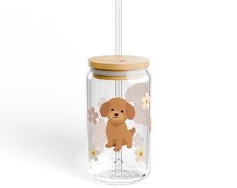 May include: A clear glass tumbler with a bamboo lid and a straw. The tumbler has a design of brown poodles and white flowers.