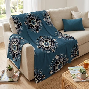 May include: A deep blue throw blanket featuring a repeating pattern of concentric circles in shades of navy, light blue, and white. The circular motifs are arranged in a scattered layout across the fabric, creating a consistent graphic design.