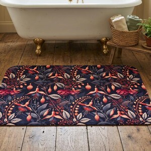 May include: A rectangular bath mat featuring a dark navy blue background with a repeating pattern of fuchsia and pink fuchsia flowers, buds, and greyish-green leaves. The mat has rounded corners and a flat, low-profile surface texture.