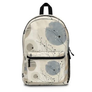 Puede incluir: Una mochila beige con una cremallera negra y un patrón de círculos grises y beige y ramas negras con pequeños puntos negros.