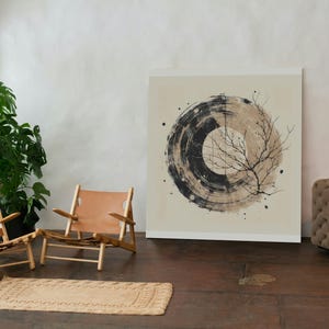 Op de afbeelding: Een abstracte kunstprint met een cirkelvormig ontwerp in zwart en beige en een takillustratie. Het kunstwerk staat in een kamer met twee houten stoelen met bruin lederen zittingen, een vloerkleed en een grote groene plant.