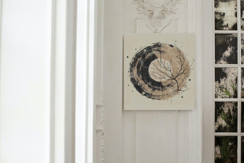 Op de afbeelding: Abstract kunstcanvas met een cirkelvormig ontwerp met zwarte en bruine penseelstreken en een delicate takillustratie. Het kunstwerk is aan een witte muur bevestigd en voegt een vleugje moderne inrichting toe. De afmetingen van het schilderij zijn niet zichtbaar.
