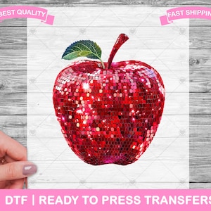 May include: A red apple with a glittery finish, perfect for adding a touch of sparkle to your crafts.  The apple is made of a shiny, red material that resembles sequins.  It is a digital design, ready to be pressed onto fabric.