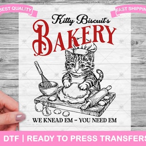 May include: A black and white illustration of a cat in a chef's hat kneading dough, with the text "Kitty Biscuit's Bakery." Includes a rolling pin, whisk, and the phrase "We Knead Em - You Need Em."