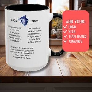 May include: White ceramic coffee mug with a black handle. The mug has a wolf logo and text that reads "2023" and "2024". The mug also has a list of names and numbers. The text "ADD YOUR: LOGO, YEAR, TEAM NAMES, COACHES" is on the right side of the mug.