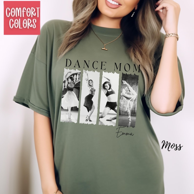 Peut inclure: T-shirt vert mousse avec l'inscription "DANCE MOM" au-dessus d'une image en noir et blanc de quatre danseuses. Le nom "Emma" est &eacute;crit en dessous de l'image. Le coin sup&eacute;rieur gauche porte l'inscription "COMFORT COLORS" dans un encadr&eacute; rose.