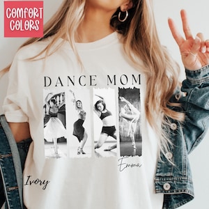 Peut inclure: T-shirt ivoire avec l'inscription "DANCE MOM" en lettres noires. Le t-shirt pr&eacute;sente quatre images en noir et blanc de danseurs. Le mot "Emma" est &eacute;crit en cursive sous les images. Les mots "Comfort Colors" sont dans un encadr&eacute; rose.