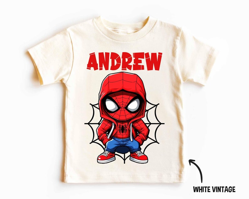 May include: A white vintage t-shirt with a cartoon image of Spiderman wearing a red and blue hoodie. The text "ANDREW" is printed in red above the image.