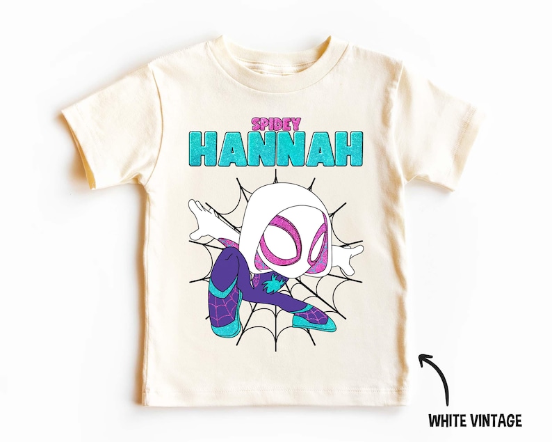 May include: White vintage t-shirt with a cartoon image of a female superhero in a spider web. The text "SPIDEY HANNAH" is printed on the shirt.