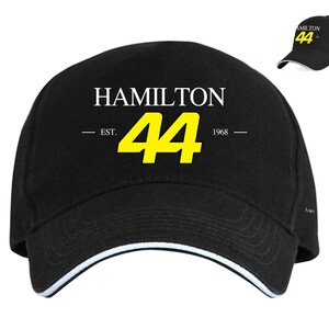May include: Black baseball cap with a white "HAMILTON" text, a yellow number "44", and the text "EST. 1968" in white.