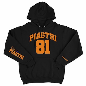 May include: Black hooded sweatshirt with orange text that reads "Piastri 81" on the front and "Oscar Piastri" on the left sleeve. The text on the right sleeve reads "Long Sleeve Hoodie".