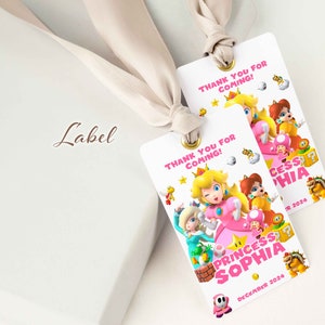 May include: Two pink and white favour tags with the text "Thank you for coming!" and a picture of Princess Peach and other characters from the Super Mario Bros. video game series. The text "Princess Sophia" and "December 2024" are also on the tags.