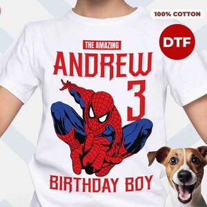 Op de afbeelding: Wit T-shirt met een rode en blauwe Spiderman-afbeelding, de tekst "The Amazing Andrew 3 Birthday Boy" en de woorden "100% Katoen" en "DTF" in rood.