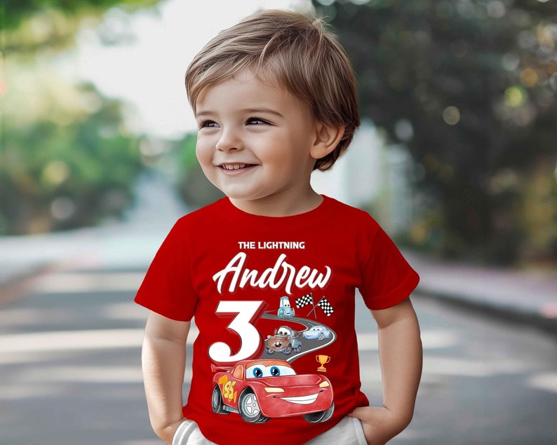 May include: A red t-shirt with a white graphic of a race car and the text "The Lightning Andrew 3".