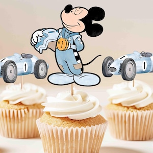 Peut inclure: Des cupcakes avec glaçage blanc, décorés de Mickey Mouse et de voitures de course. Mickey Mouse porte une combinaison de course et tient un casque. Les voitures de course bleu clair portent le numéro 1. Les cupcakes sont dans des caissettes en papier.