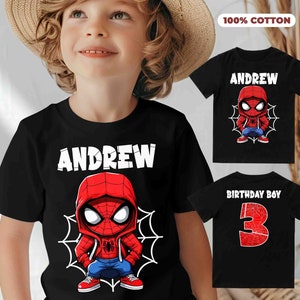 May include: Black t-shirt with a cartoon Spiderman design and the name "Andrew" printed in white. The shirt is 100% cotton.
