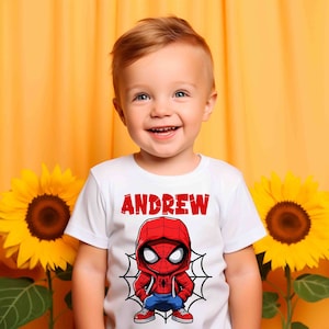 May include: A white t-shirt with a red and blue cartoon Spider-Man graphic and the name "ANDREW" printed in red letters.