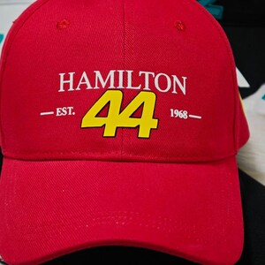 May include: Red baseball cap with a white "HAMILTON 44 EST. 1968" logo in yellow.