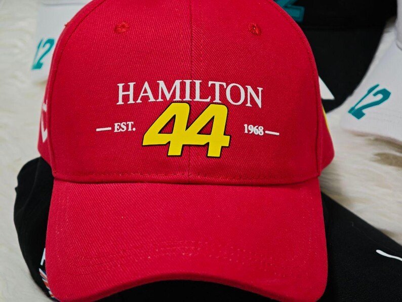 May include: Red baseball cap with a white "HAMILTON 44 EST. 1968" logo in yellow.