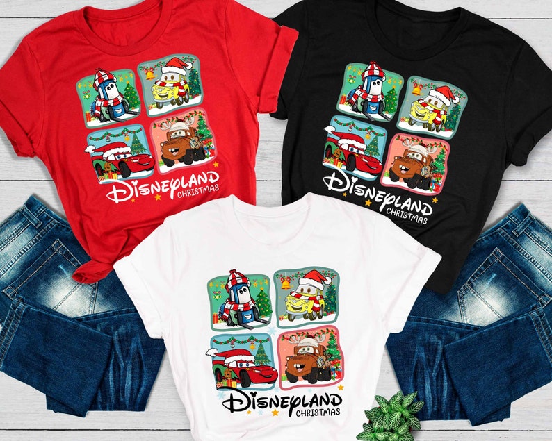 May include: Three t-shirts with a Christmas theme featuring characters from the Disney Pixar movie Cars. The shirts are red, black, and white. The design features a grid of four squares with a different character in each square. The text "Disneyland Christmas" is printed below the grid.