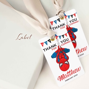 Puede incluir: Dos etiquetas de regalo blancas con banderines rojos y azules, una imagen de dibujos animados de Spiderman colgando boca abajo, y el texto "&iexcl;Gracias por venir!" y "Matthew Febrero 2024".