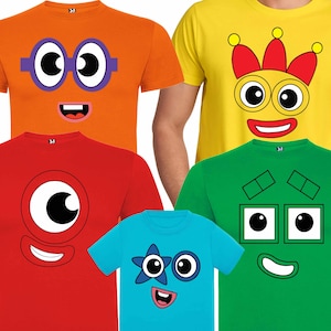 Puede incluir: Cinco camisetas con diferentes caras de dibujos animados impresas en ellas. Las caras son todas sonrientes y tienen ojos grandes. Las camisetas son de varios colores, incluyendo naranja, amarillo, rojo, verde y azul.